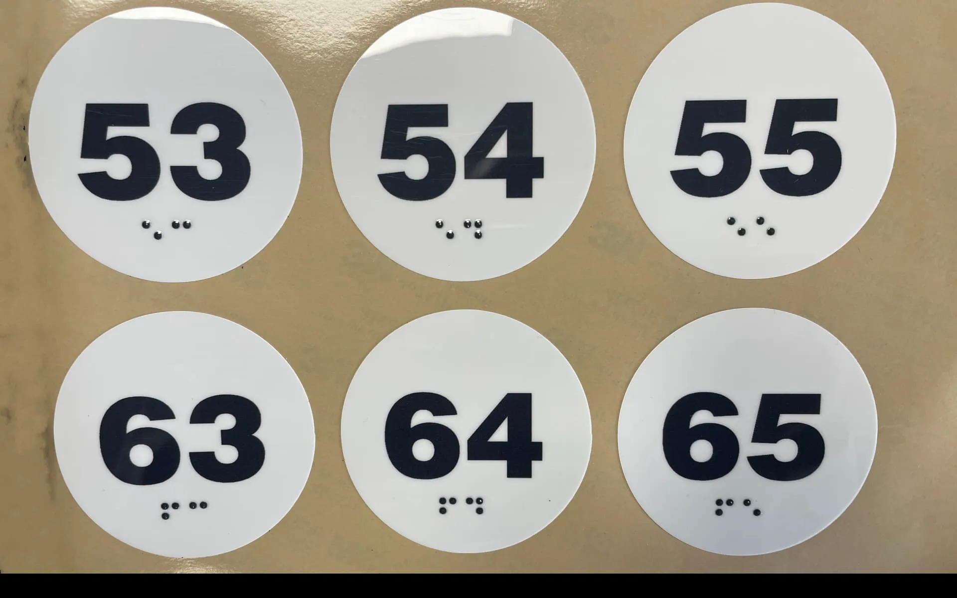 Custom Braille labels — numbered tactile stickers with embossed Grade 1 Braille cells manufactured by Adcal Labels